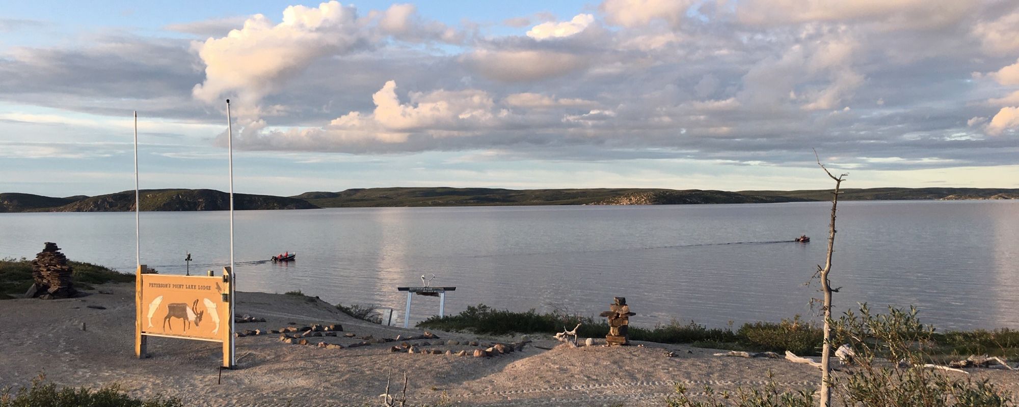 Two boats heading out on a summer evening on Point Lake to go fishing for trophy lake trout in the Northwest Territories Canada